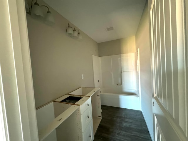 bathroom with shower / bathing tub combination and hardwood / wood-style floors