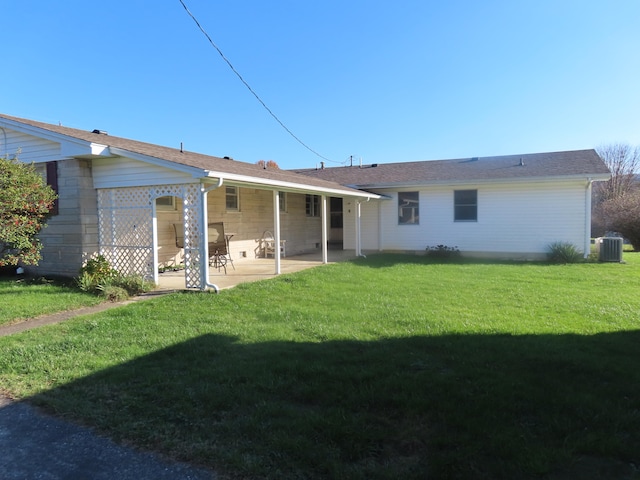 back of house with central AC, a patio area, and a lawn