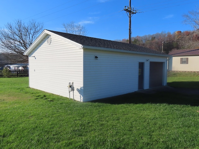 exterior space with a garage, an outbuilding, and a yard