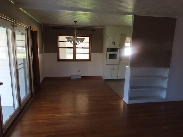 unfurnished dining area with a chandelier and dark hardwood / wood-style floors