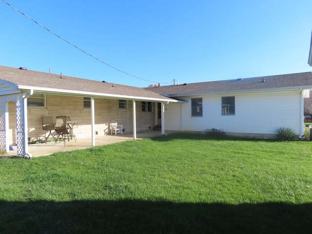 rear view of house with a patio and a lawn