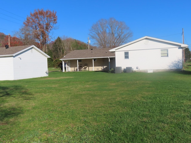 back of property with a yard and central air condition unit