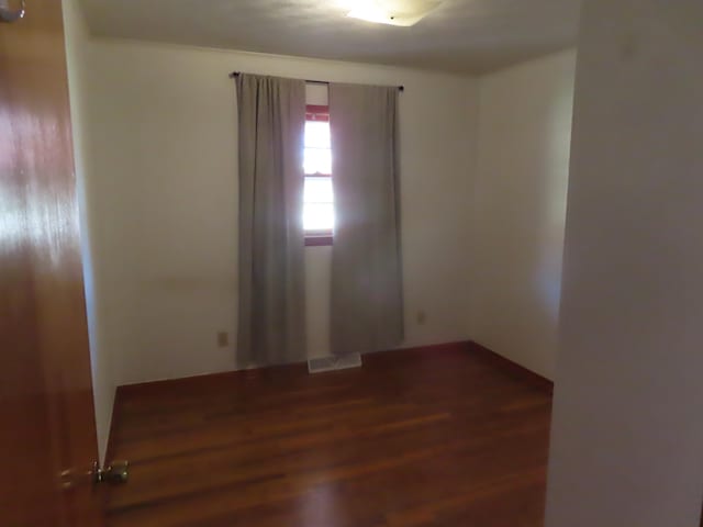 spare room with dark wood-type flooring