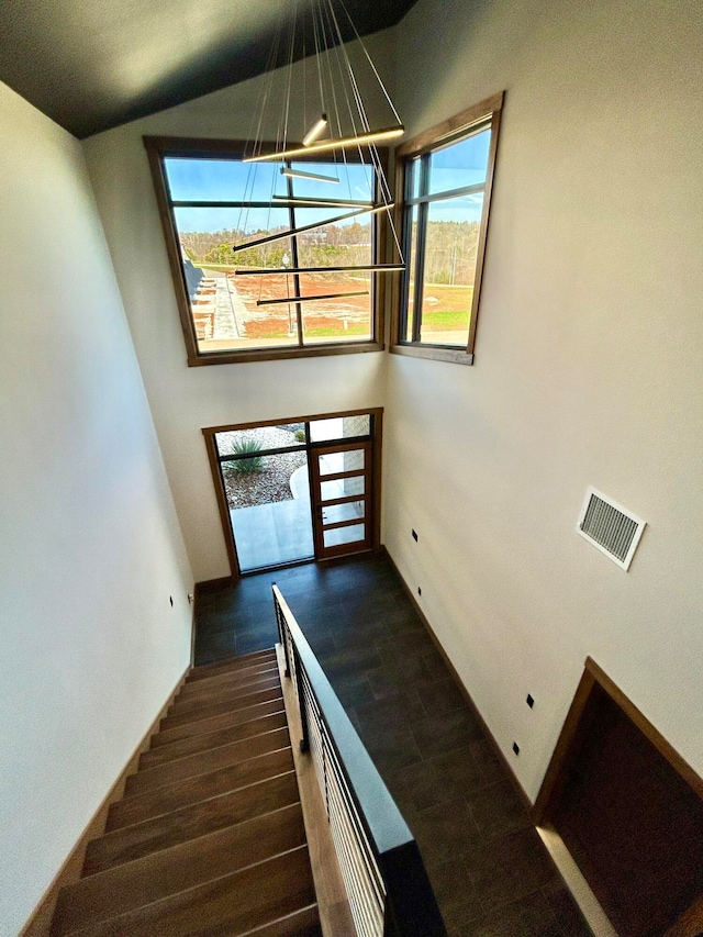 staircase featuring hardwood / wood-style flooring and an inviting chandelier