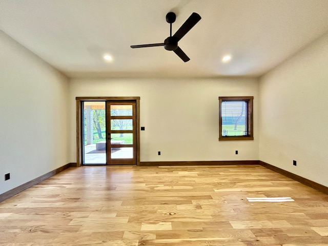 empty room with ceiling fan, a wealth of natural light, light wood-type flooring, and french doors