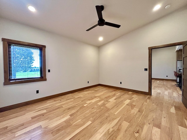 unfurnished room with ceiling fan, lofted ceiling, and light wood-type flooring