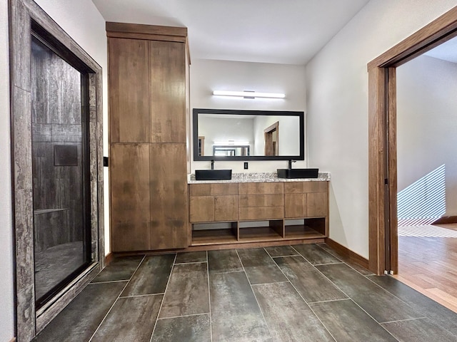 bathroom with hardwood / wood-style floors, vanity, and a shower with door