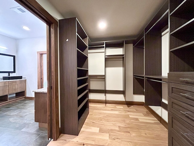 walk in closet with light wood-type flooring