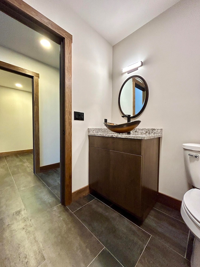 bathroom featuring vanity, tile patterned floors, and toilet