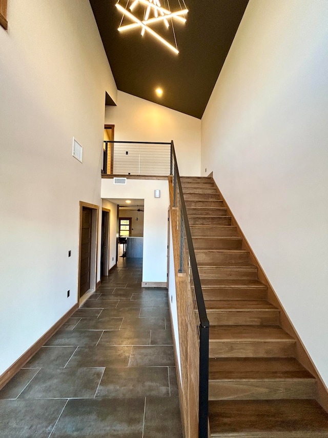 staircase featuring high vaulted ceiling