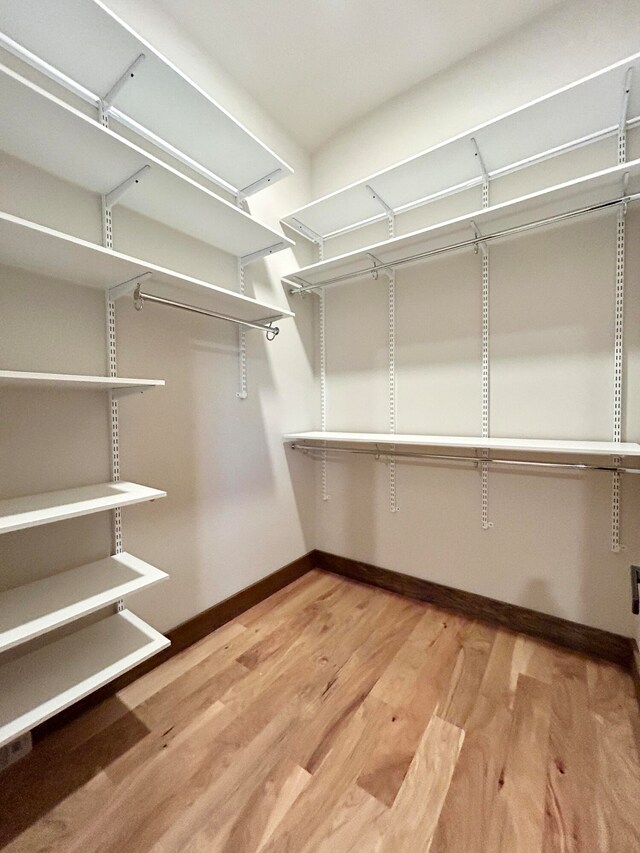 spacious closet with hardwood / wood-style floors