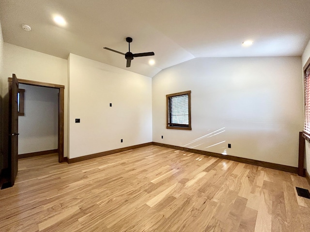 empty room featuring ceiling fan, vaulted ceiling, and light wood-type flooring