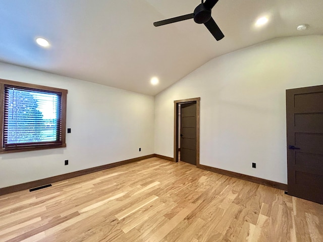 empty room featuring ceiling fan, light hardwood / wood-style floors, and vaulted ceiling