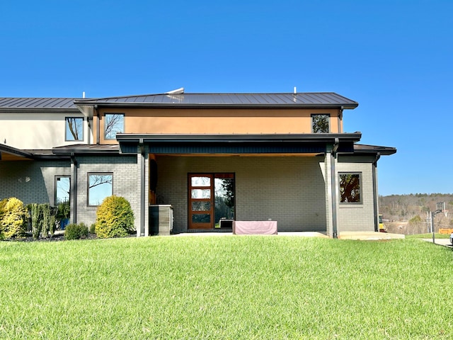 rear view of house with a patio area and a lawn