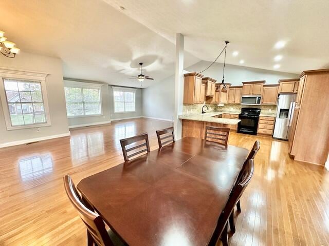 151 Surrounding Hills Dr, Somerset, KY 42503 - dining area featuring ceiling fan with notable chandelier, a healthy amount of sunlight, light hardwood / wood-style flooring, and vaulted ceiling