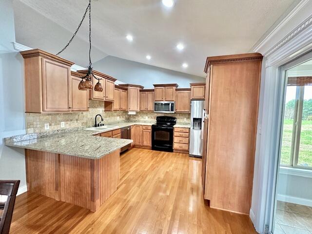 151 Surrounding Hills Dr, Somerset, KY 42503 - kitchen featuring vaulted ceiling, appliances with stainless steel finishes, tasteful backsplash, light hardwood / wood-style floors, and kitchen peninsula
