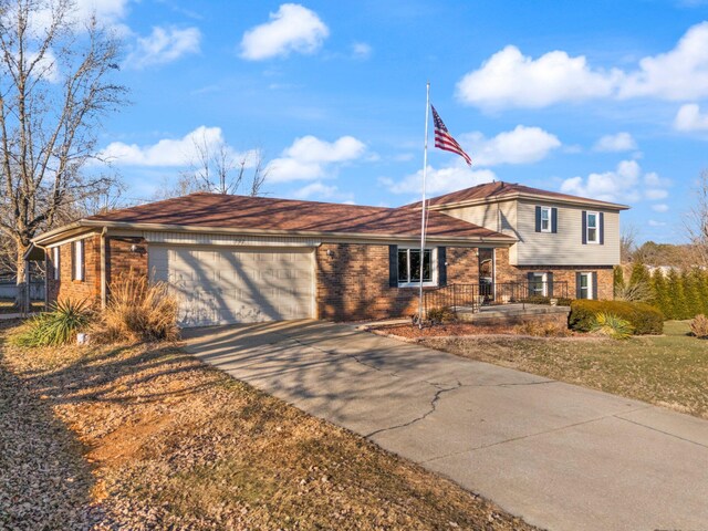 split level home featuring a garage and a front lawn