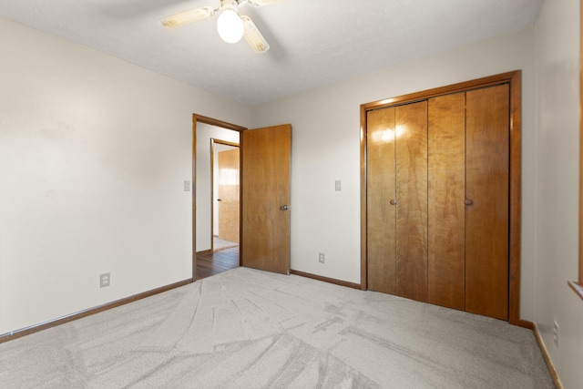 unfurnished bedroom with light carpet, a closet, and ceiling fan