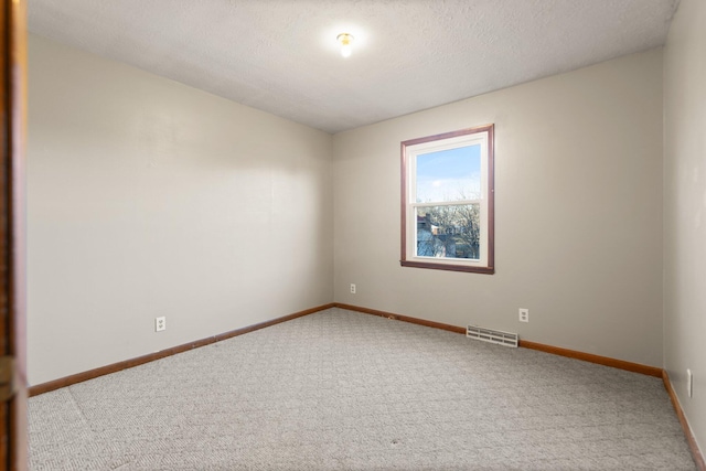 carpeted spare room featuring a textured ceiling