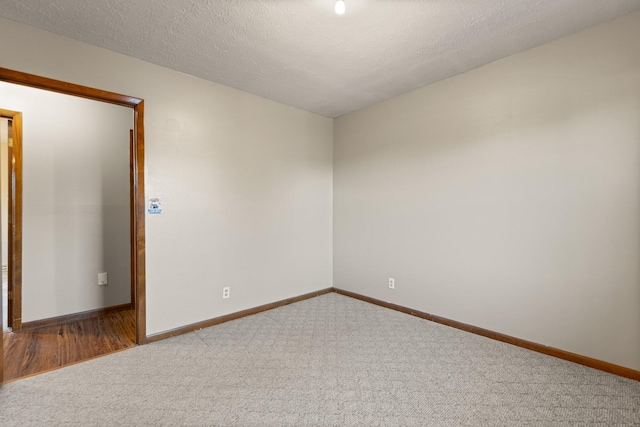 carpeted spare room with a textured ceiling