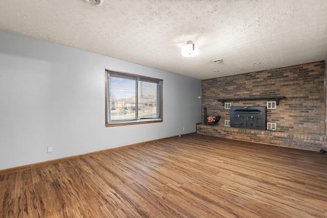 unfurnished living room featuring wood-type flooring and a textured ceiling