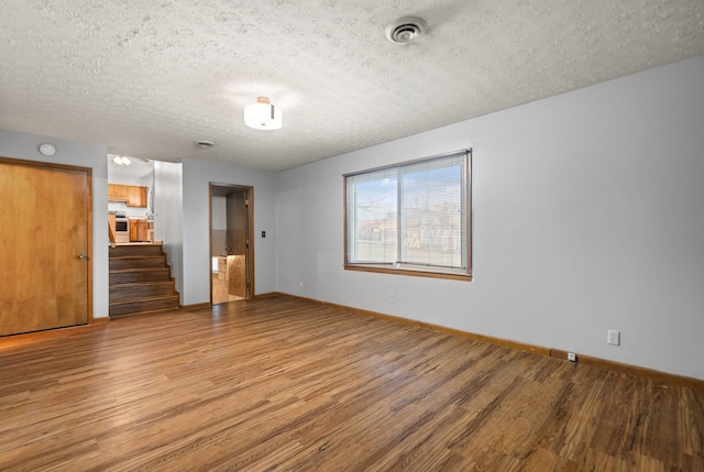 unfurnished living room featuring light hardwood / wood-style flooring and a textured ceiling