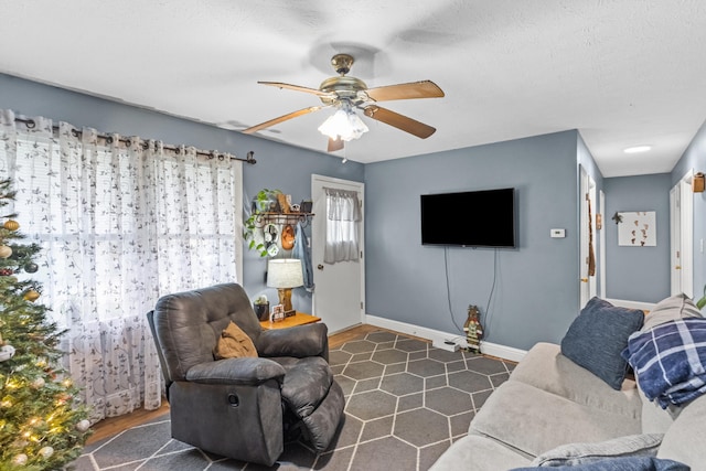 living room with a textured ceiling, dark hardwood / wood-style flooring, and ceiling fan