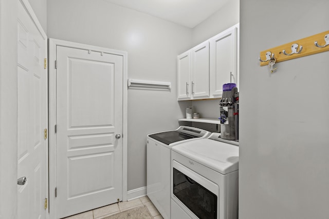 laundry area featuring cabinets, washing machine and dryer, and light tile patterned floors