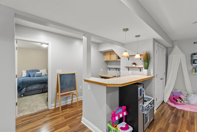 kitchen featuring light brown cabinetry, dark hardwood / wood-style floors, decorative light fixtures, and appliances with stainless steel finishes