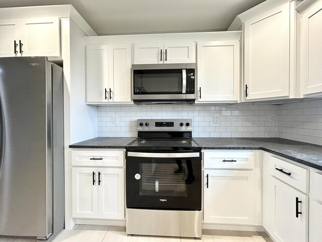 kitchen with a center island, dark countertops, backsplash, lofted ceiling with beams, and appliances with stainless steel finishes