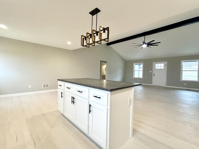 unfurnished living room featuring baseboards, visible vents, and beam ceiling