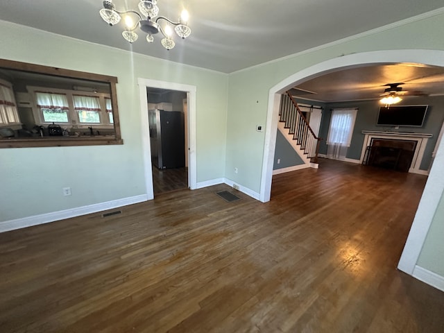 unfurnished living room with crown molding, ceiling fan with notable chandelier, and dark hardwood / wood-style floors