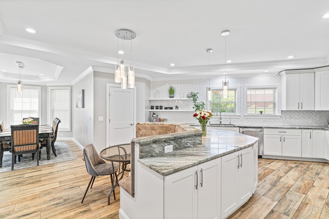 kitchen with decorative light fixtures, light hardwood / wood-style flooring, and a wealth of natural light