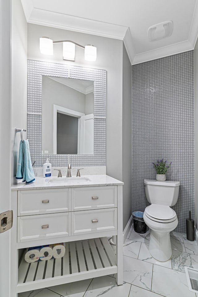 bathroom with vanity, toilet, and crown molding