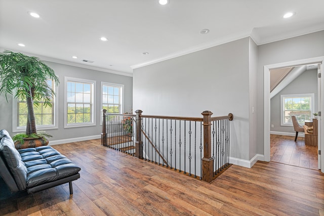 living area with hardwood / wood-style floors and ornamental molding