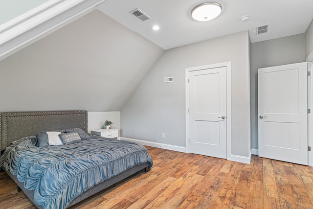 bedroom with hardwood / wood-style flooring and vaulted ceiling