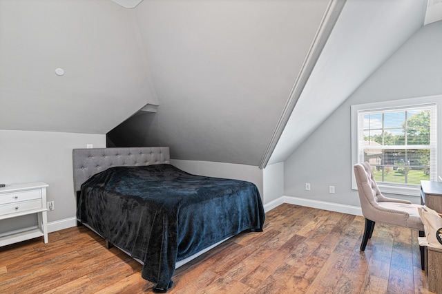 bedroom featuring hardwood / wood-style floors and lofted ceiling