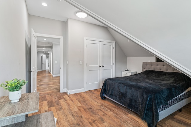 bedroom featuring wood-type flooring and vaulted ceiling