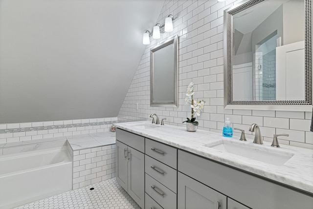 bathroom with tile patterned floors, vanity, a tub to relax in, and tile walls