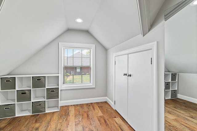 bonus room with lofted ceiling and light wood-type flooring