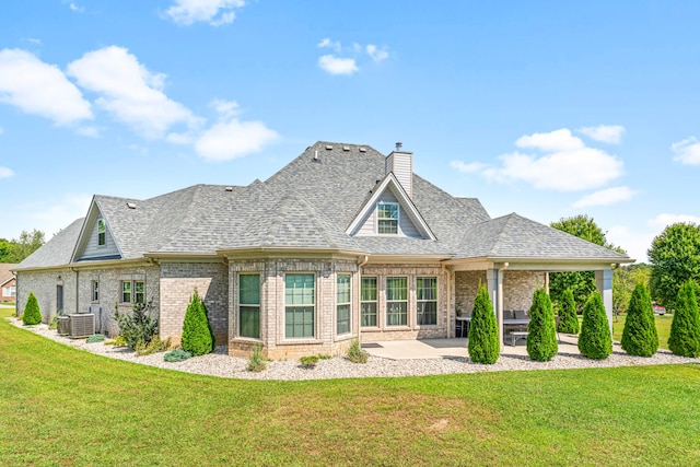 back of house featuring a yard, central AC, and a patio area