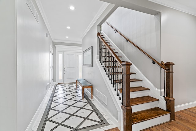 stairway featuring hardwood / wood-style floors and ornamental molding