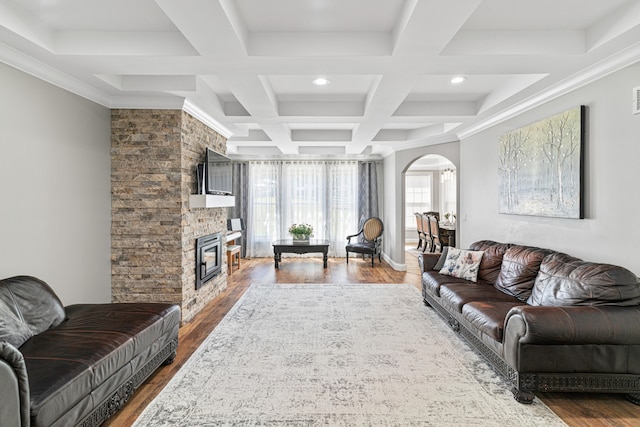 living room with dark hardwood / wood-style flooring, coffered ceiling, crown molding, beam ceiling, and a fireplace