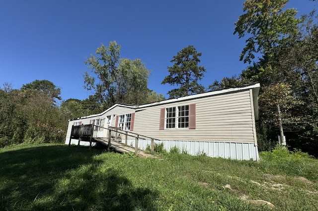 view of side of property featuring a yard and a deck