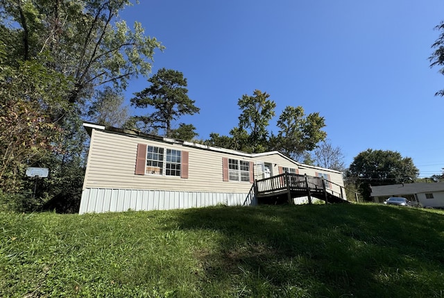 view of front of house with a front yard and a deck