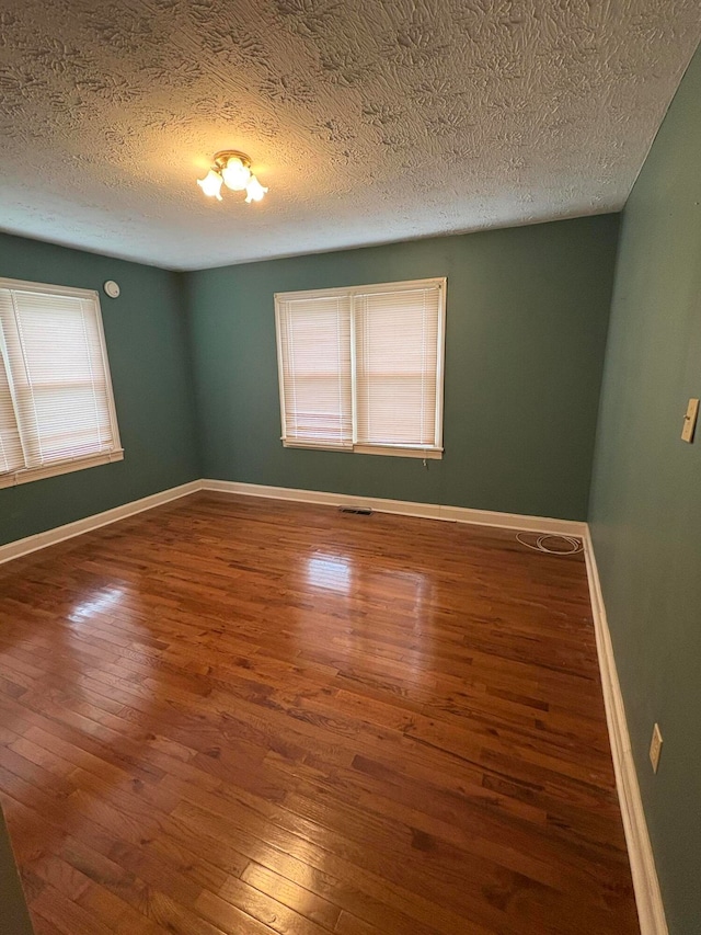 empty room featuring hardwood / wood-style flooring and a textured ceiling