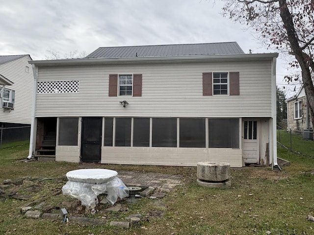 rear view of property featuring a lawn and cooling unit