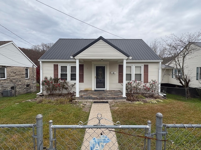 bungalow-style house with a front lawn, a gate, a fenced front yard, and metal roof