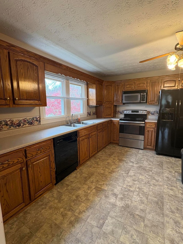 kitchen featuring ceiling fan, sink, black appliances, and a textured ceiling