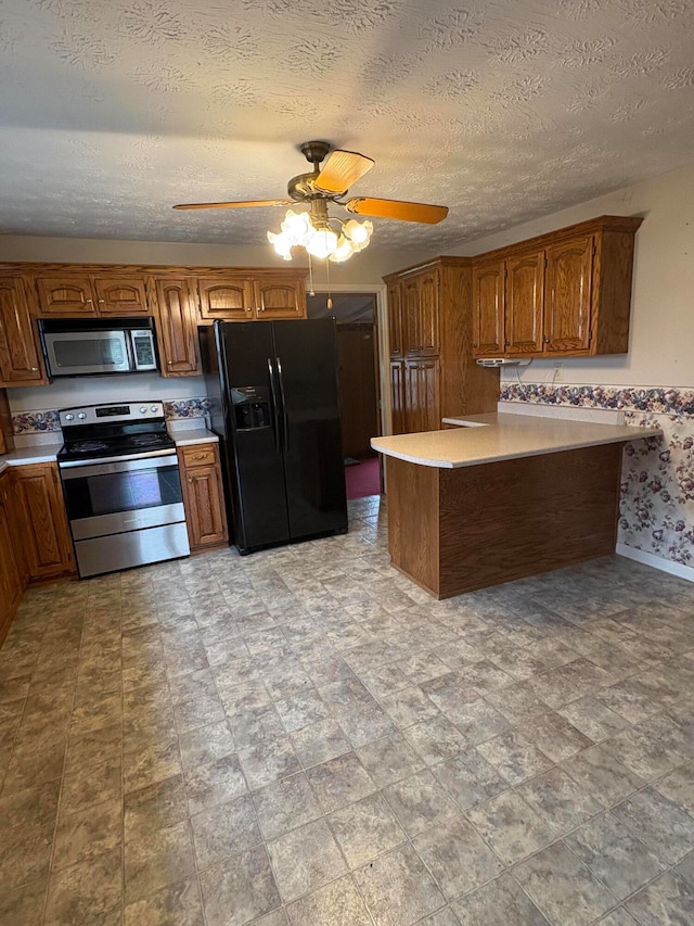 kitchen featuring appliances with stainless steel finishes, a textured ceiling, and ceiling fan